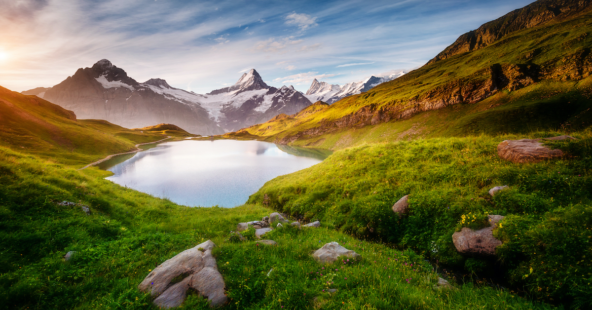 Lake Bachalpsee, Switzerland surrounded by green grass with snowcapped mountains in the background - 25th Wedding Anniversary Ideas