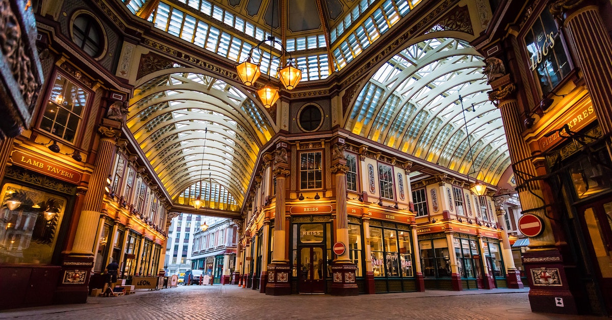 Diverging corridors lined with shops and glass ceilings in Leadenhall Market, London