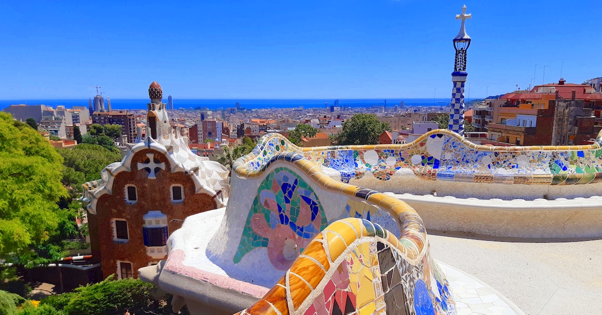 Colorfully-tiled short wall looking out over the rest of Parc Güell in Barcelona
