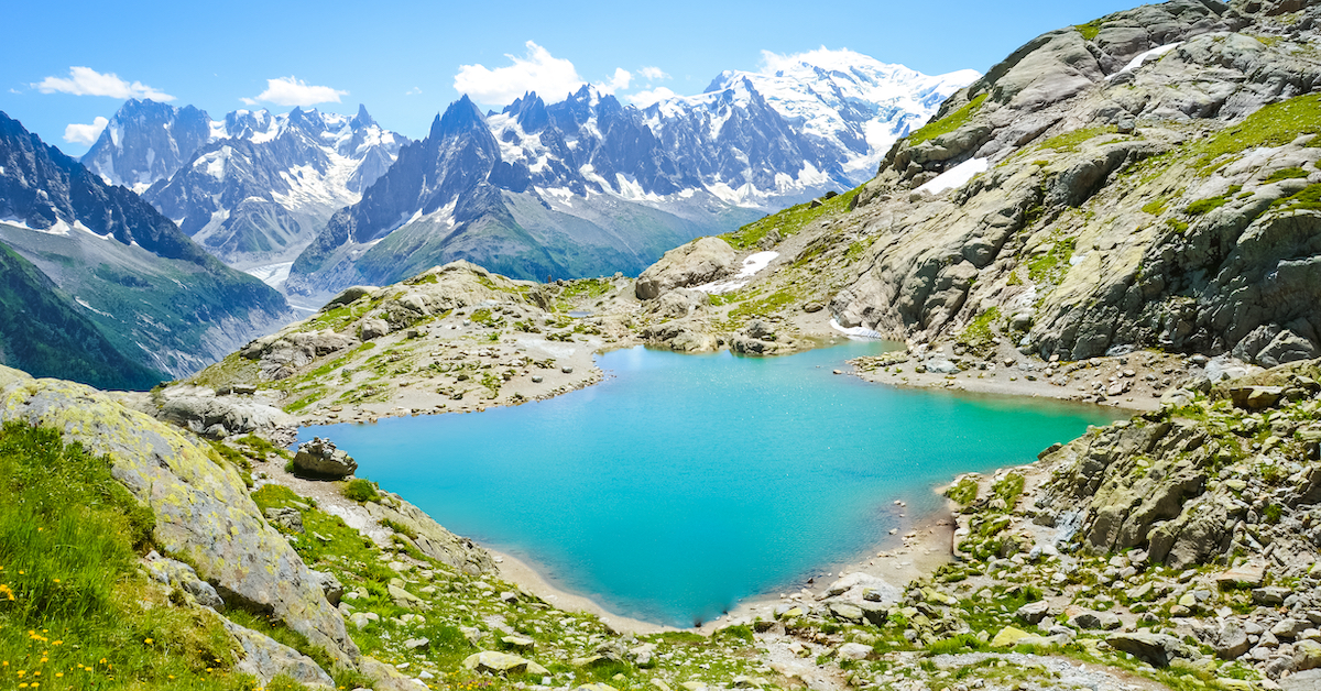 Small blue lake amid the snow-capped French Alps, one of the best France honeymoon destinations