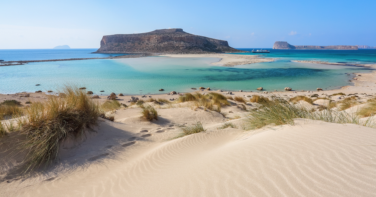 Cape Tigani bridged to mainland Crete by a strip of beach with blue water on either side