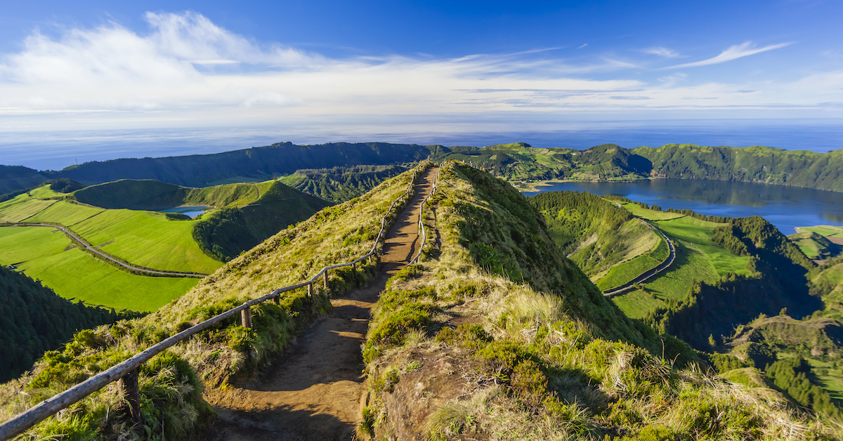 Trail leading out towards a green landscape of volcanic craters in the Azores, one of the best Portugal honeymoon destinations