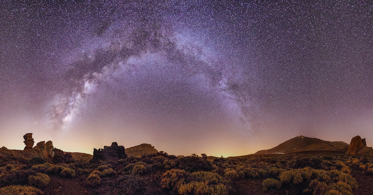 Bright night sky with the Milky Way visible over a desert landscape