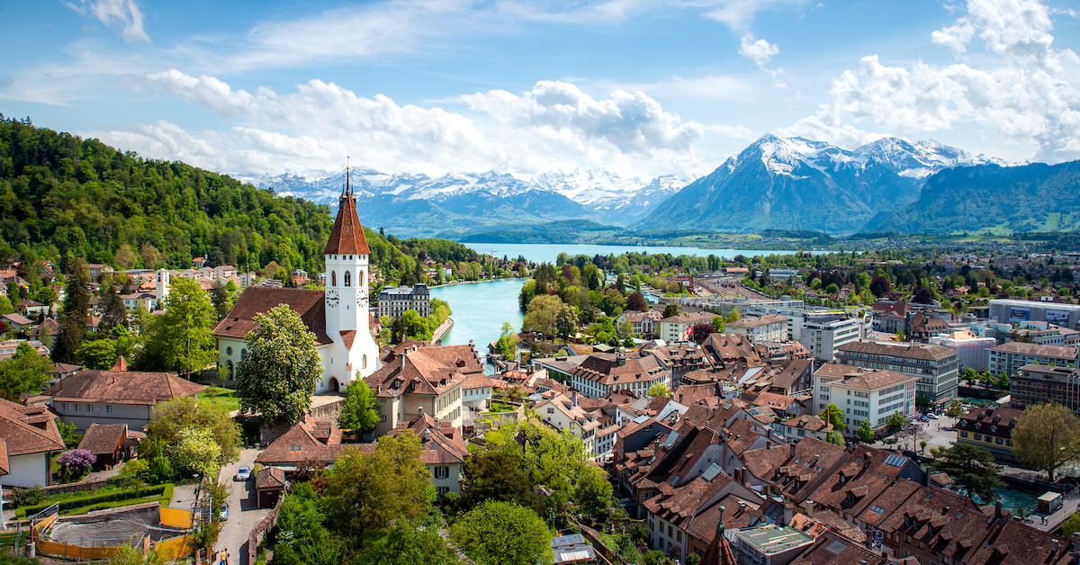 Aerial view of the medieval city of Thun in Switzerland's Bernese Oberland with a lake and snow-capped mountains in the background