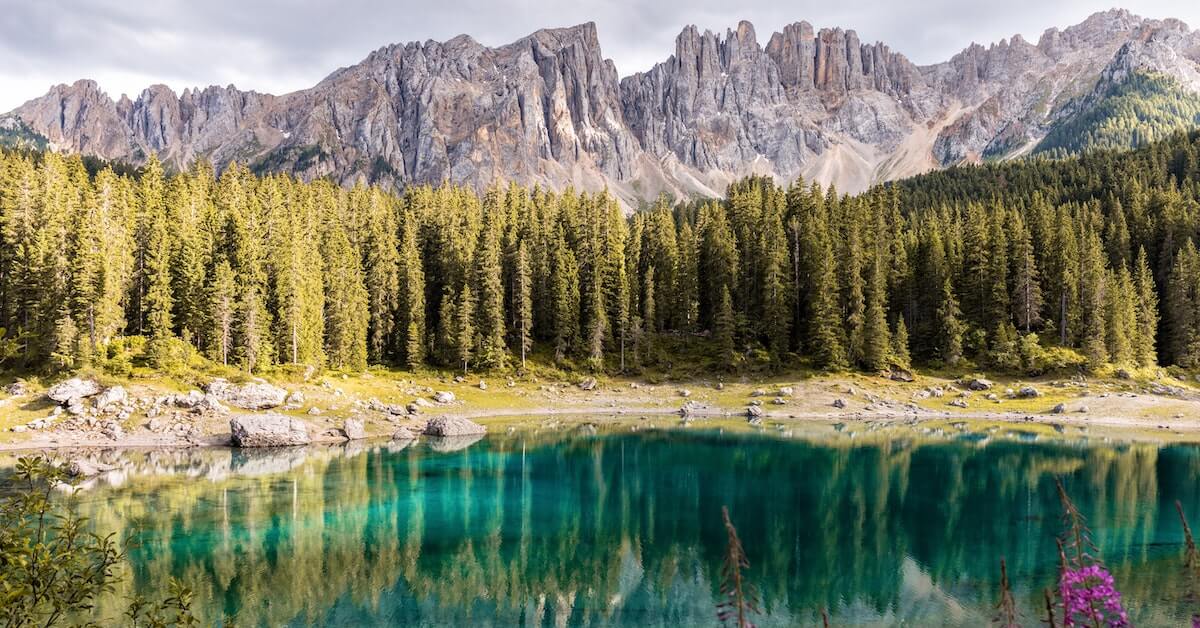 Jagged portion of the Dolomites in the background reflected in the turquoise Lake Carezza