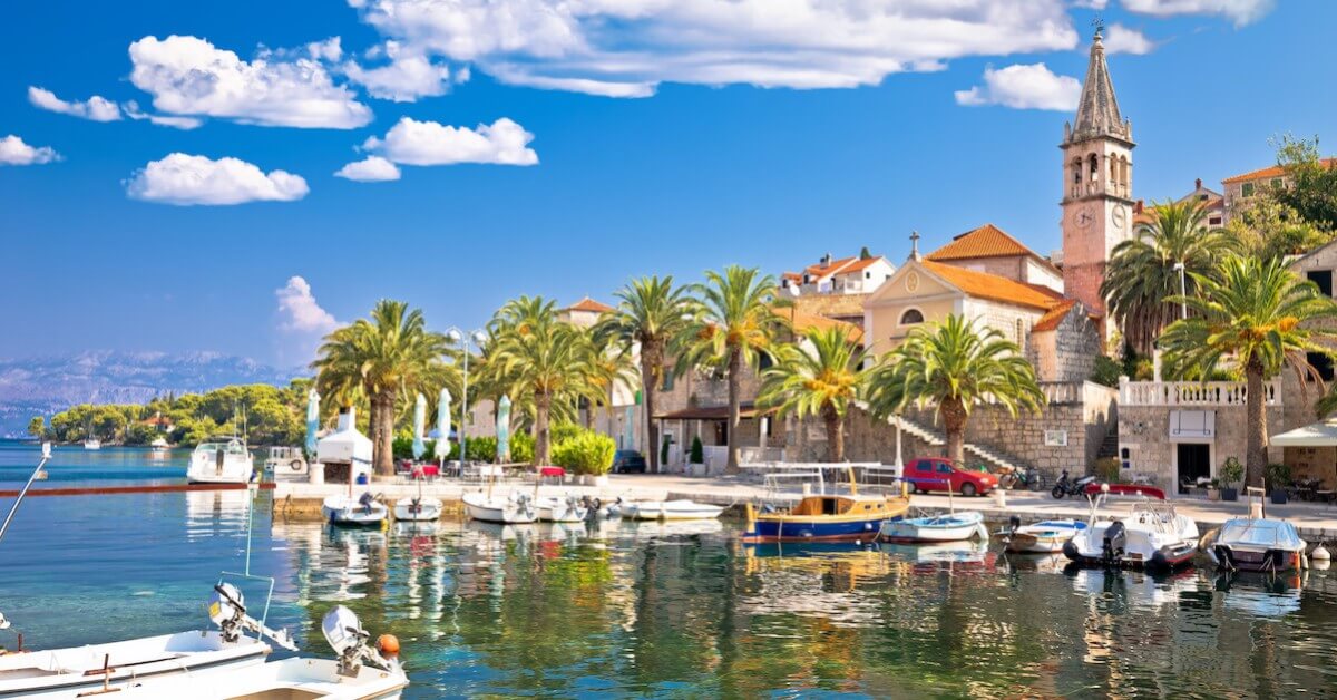 Boats in a harbor with a stone town in Croatia’s Dalmatian Islands in the background