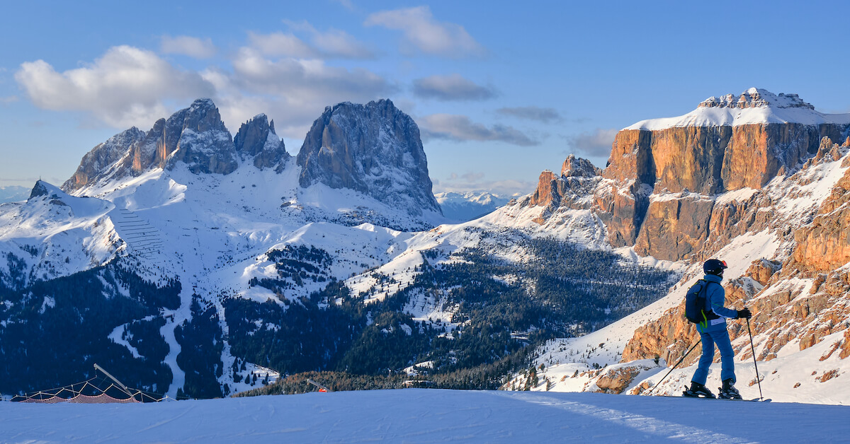 Skier in the foreground with the snowy Dolomites of Italy in the background