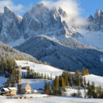 The village of Santa Maddalena, Italy and the Dolomites mountain range in the background covered in snow