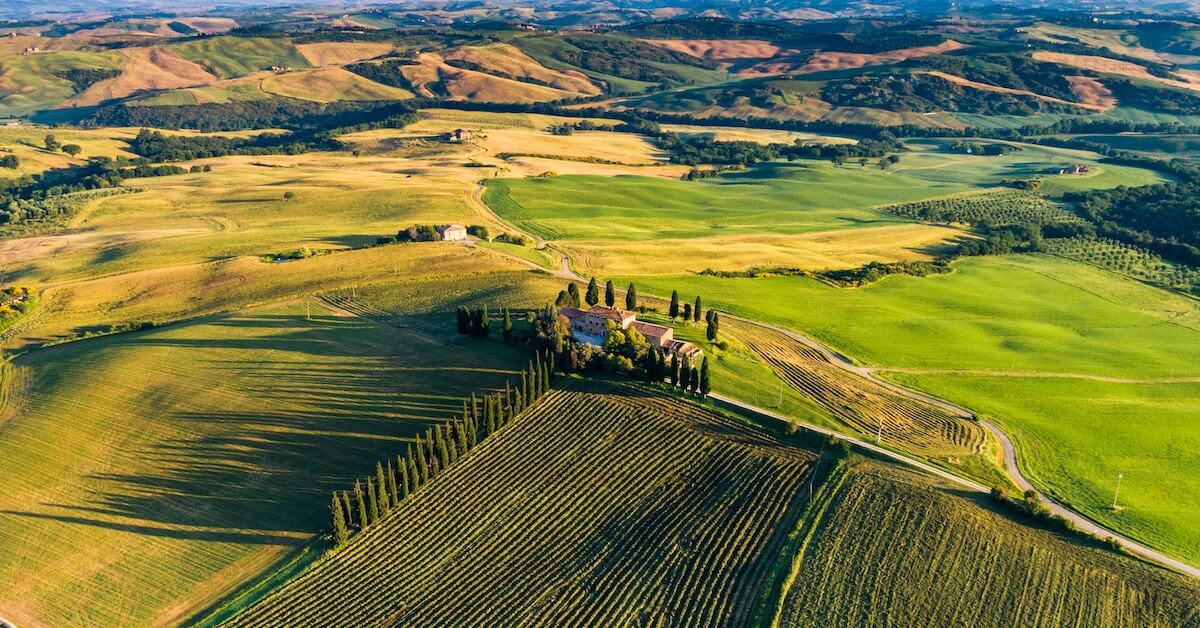 Aerial view of a stone villa surrounded by green hills in Tuscany, Italy