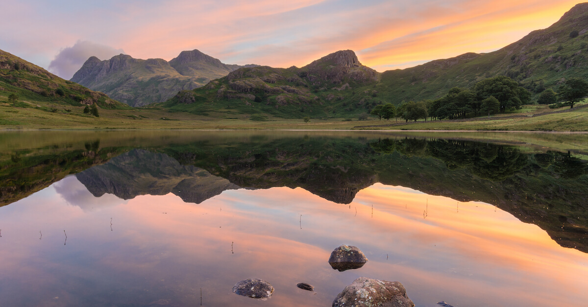 Sunrise over a lake with mountains in the background in the Lake District, United Kingdom