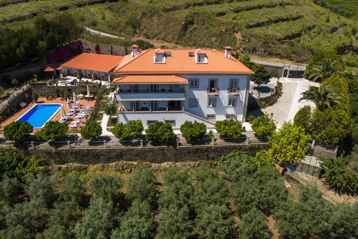 <b>Casa de Sao Domingos, Peso da Regua</b> - This quaint B&B gets its charm from the plants growing in terracotta pots, its stone wall next to the pool, and the sun loungers with parasols. The views of the Duoro River with hills in the background makes for a perfect backdrop for your relaxing vacation.