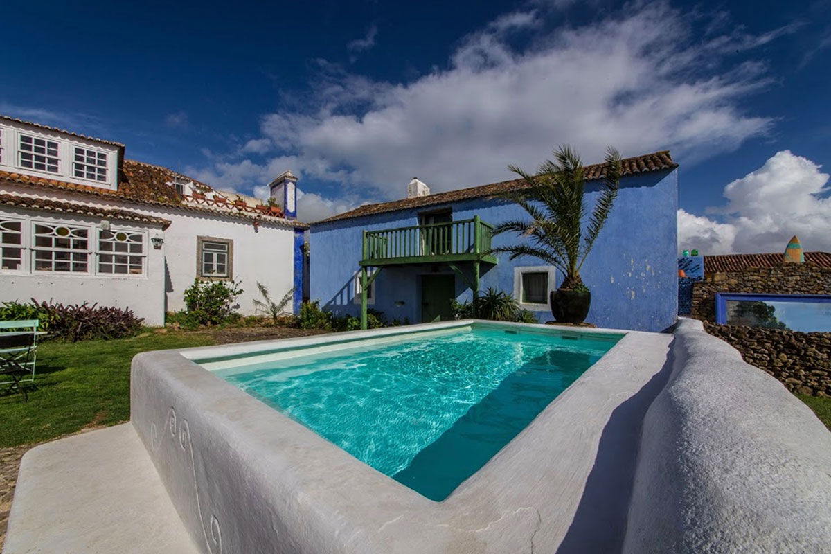 <b>Casa Paco D’Ilhas, Ericeira</b> - With heritage styling and a bright, colorful palette, the Casa Paco D’Ilhas immerses guests in a holistic leisure approach to life. With cabanas overgrown with tropical plants, a white stone pool, and décor with a rustic edge, this quaint hotel provides guests with an authentic experience - the perfect ocean getaway.