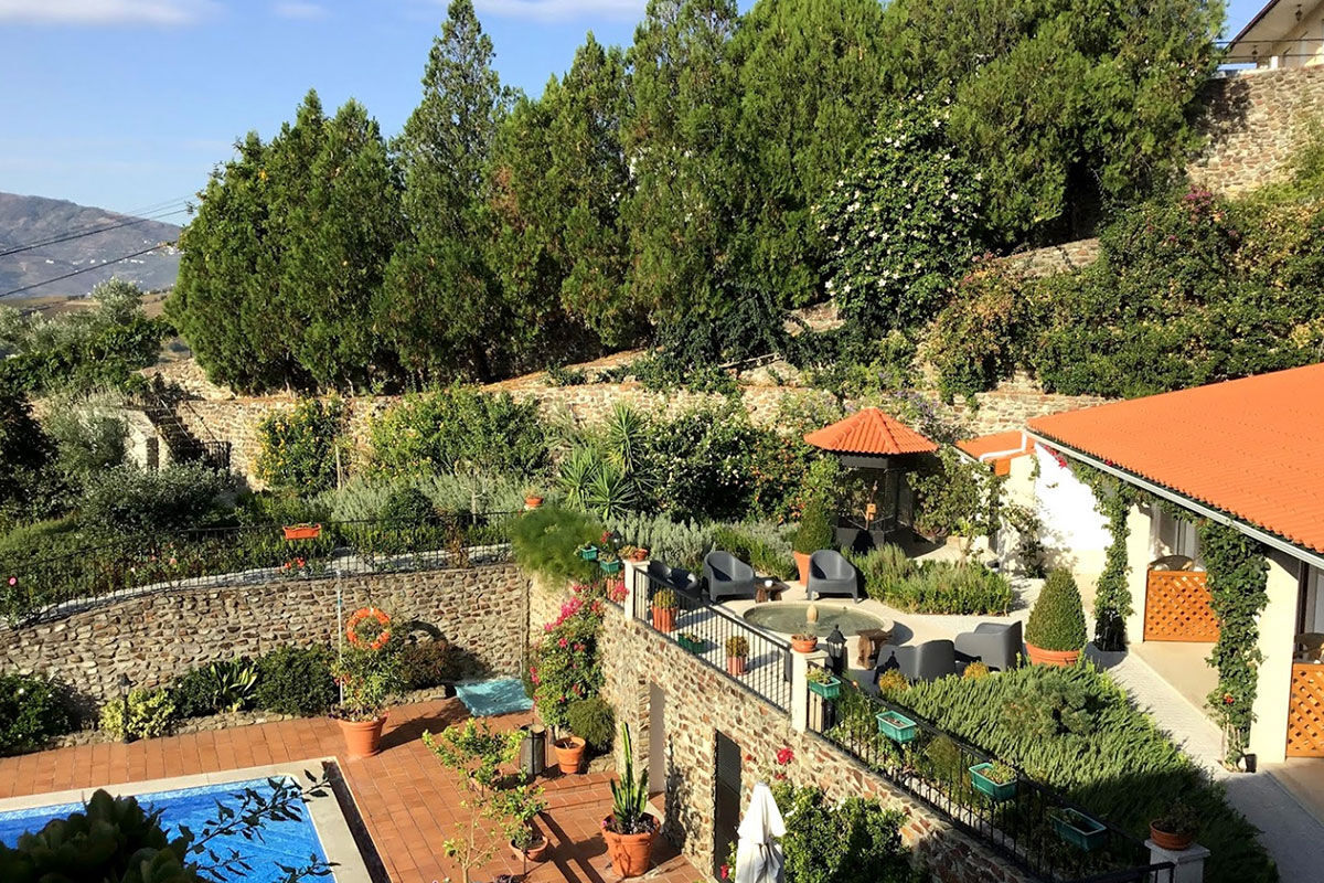 <b>Casa de Sao Domingos, Peso da Regua</b> - This quaint B&B gets its charm from the plants growing in terracotta pots, its stone wall next to the pool, and the sun loungers with parasols. The views of the Duoro River with hills in the background makes for a perfect backdrop for your relaxing vacation.