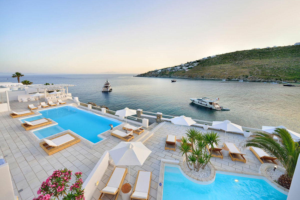 <b>Nissaki, Platis Yialos</b> - Surrounded by golden sunlight and clear blue waters, this luxury boutique hotel is set in traditional whitewashed buildings and features clean, streamline furnishings. Guests dine next to the Aegean Sea, swim in one of two pools with sun loungers nearby, and are only steps away from the renowned Platis Yialos Beach.