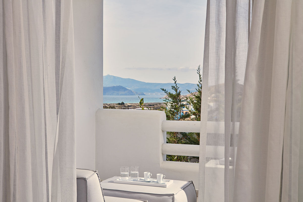 <b>18 Grapes, Agios Prokopios</b> – Within walking distance to Agios Prokopios beach, the 18 Grapes Hotel hints of Cycladic features amidst comfortable design. With a care-free island vibe, yet an attention to detail, this modern resort has everything you need: a two-level pool with lounge decks, sophisticated roof terrace, and the Grape Sunset bar restaurant.